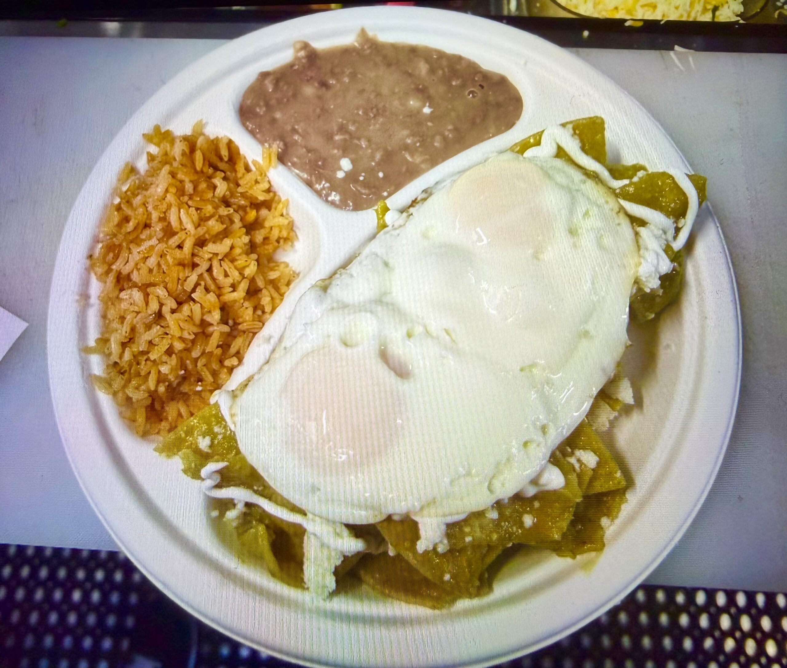 A white plate filled with rice, beans and eggs on top