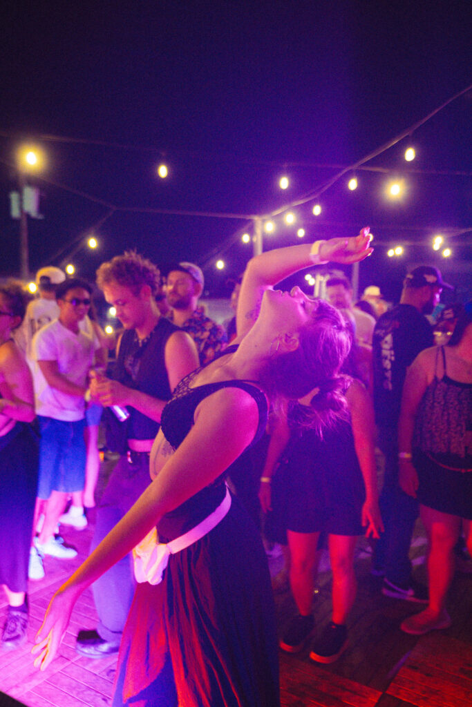 Woman dancing wearing all black at rooftop bar in Portland, Oregon