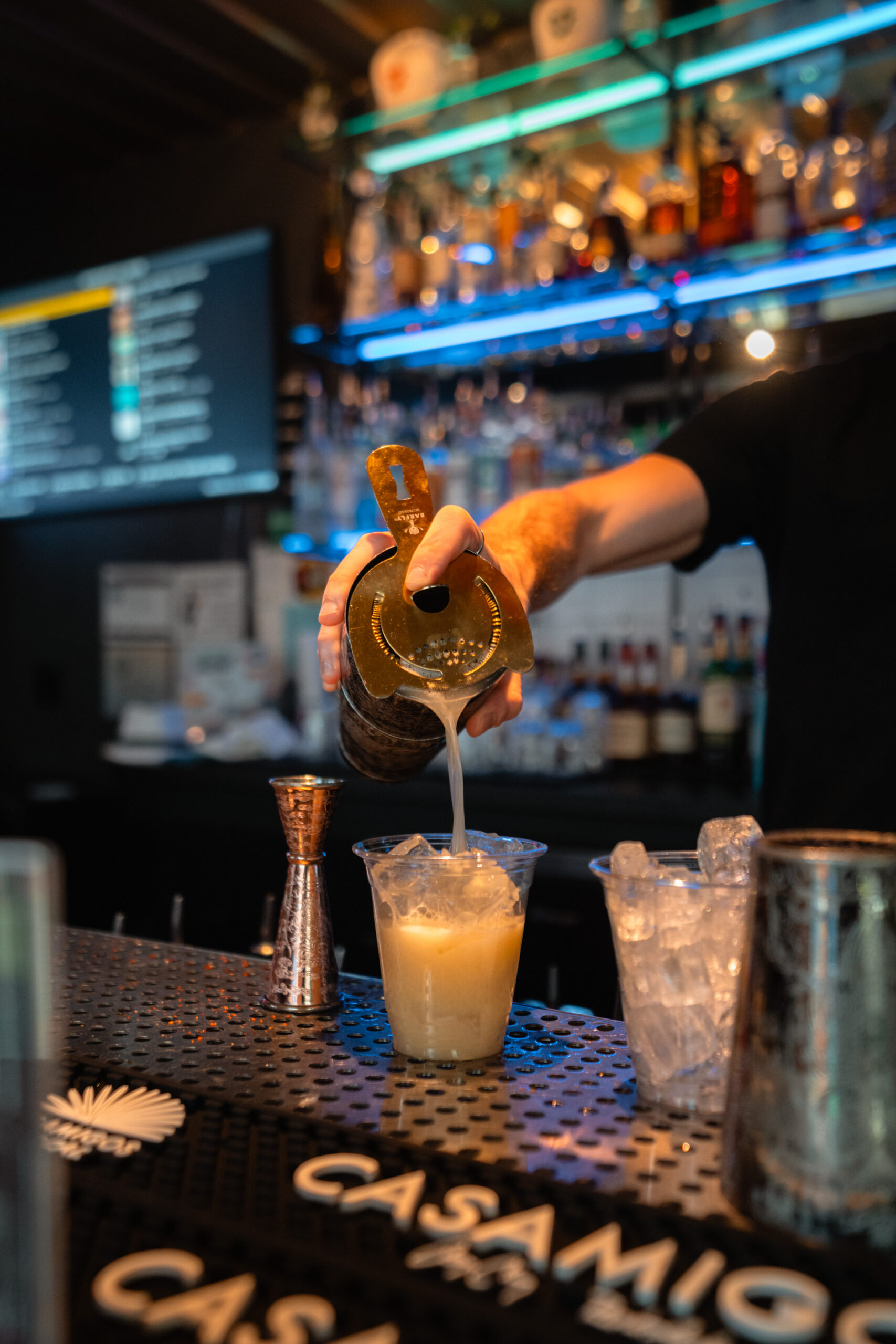 Margarita being poured into glass over ice