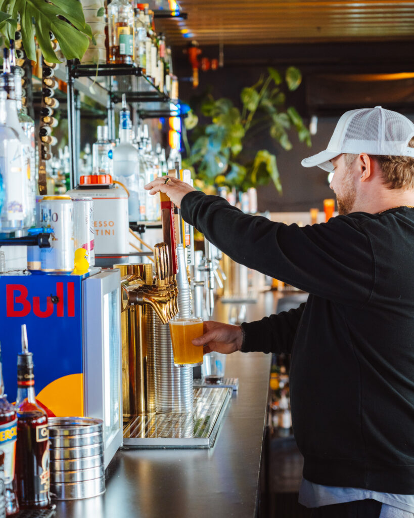 Man pouring beer from tap into glass cup
