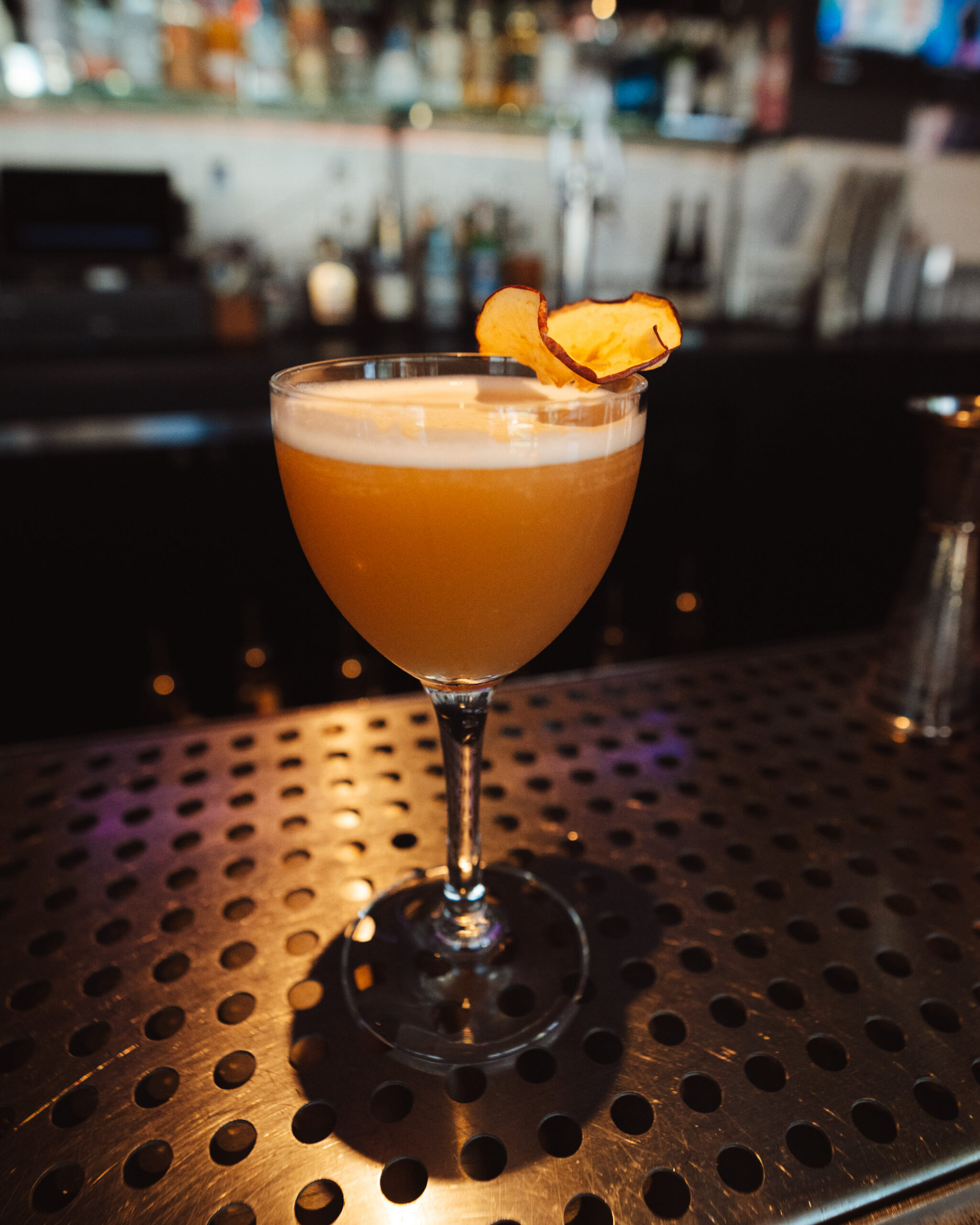 Bar seasonal autumn cocktail with apple garnish on silver bar