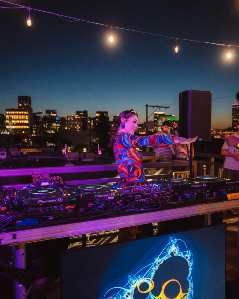 Female DJ In Portland at live music venue Wonderlove with city sky in background